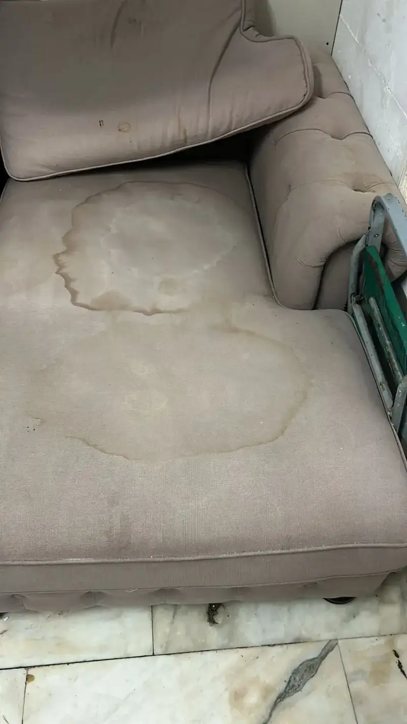 Zitting van een stoffen bank in een woonkamer, dof en vuil van dagelijks gebruik
