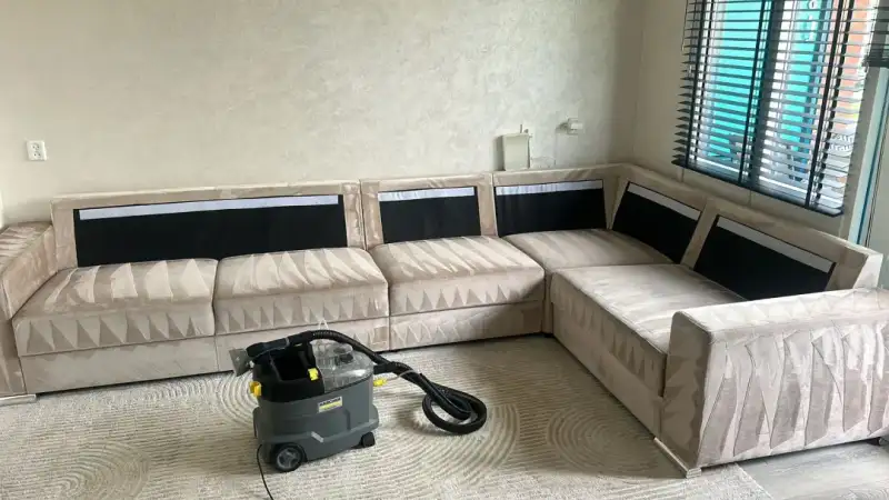 Beige hoekbank en vloerkleed in een woonkamer, allebei net gereinigd